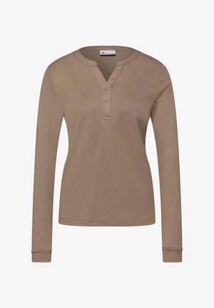 Beżowa koszula henley z długim rękawem, z czterema guzikami i okrągłym kołnierzem, wykonana z miękkiego dzianinowego materiału.