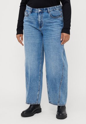 Bredde ben blå denim jeans med mid-høyde liv, med tonede sømmer, forkantlommer og en jevn finish. Kombinert med svarte ankelstøvler.