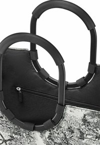 Zwarte draagtas met gestructureerde handvatten, een ritsvak en een bedrukt ontwerp met boompatronen op een lichte achtergrond.