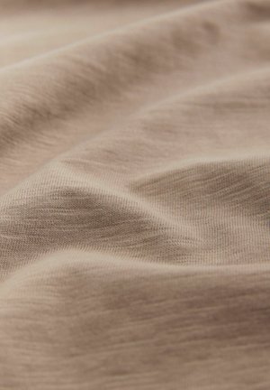Tessuto beige chiaro con una consistenza liscia, caratterizzato da morbide pieghe e sottili variazioni di colore. Miscela di cotone con dettagli in fine costina.