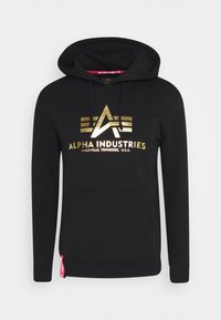 Hoodie nero realizzato in morbido tessuto con logo dorato; include una tasca centrale e cordini sul cappuccio per un fit regolabile.