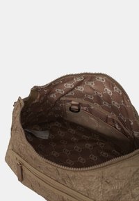 Borsa in tessuto beige con esterno testurizzato, chiusura con zip e fodera a motivo marrone. Include una piccola tasca in rete e una clip all'interno.