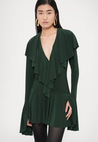 Zielona sukienka z długim rękawem, głębokim dekoltem w kształcie litery V i warstwowymi falbanami, z rozkloszowanymi rękawami i spódnicą.