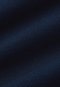 Granatowy, teksturowany materiał z prążkowanym wzorem, ściśle tkany, ukazujący głębię i wymiar na powierzchni tkaniny.