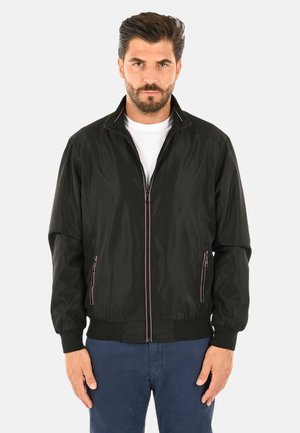 Giacca bomber nera con zip frontale, cuciture rosa a contrasto e tasche laterali. Realizzata in tessuto leggero, presenta polsini e vita elasticizzati.