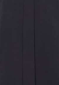 Tessuto blu navy con una texture liscia, caratterizzato da una cucitura verticale al centro. Design semplice e minimalista.
