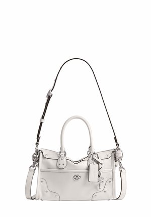Sac à main en cuir blanc avec double poignée, une bandoulière noire réglable, une poche avant et un porte-clés avec un détail de serrure.