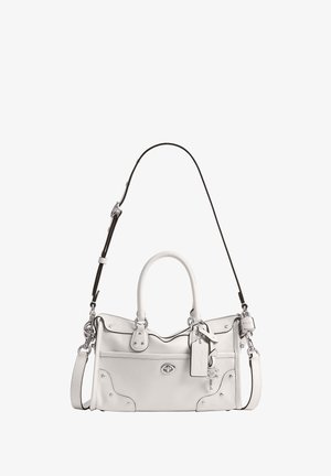 Sac à main en cuir blanc avec double poignée, une bandoulière noire réglable, une poche avant et un porte-clés avec un détail de serrure.