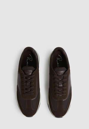 Barna sportcipők, amelyek nubuk és hálós anyagok keverékéből készültek, fűzővel, lekerekített orral és fehér gumitalppal rendelkeznek.