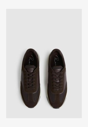 Barna sportcipők, amelyek nubuk és hálós anyagok keverékéből készültek, fűzővel, lekerekített orral és fehér gumitalppal rendelkeznek.