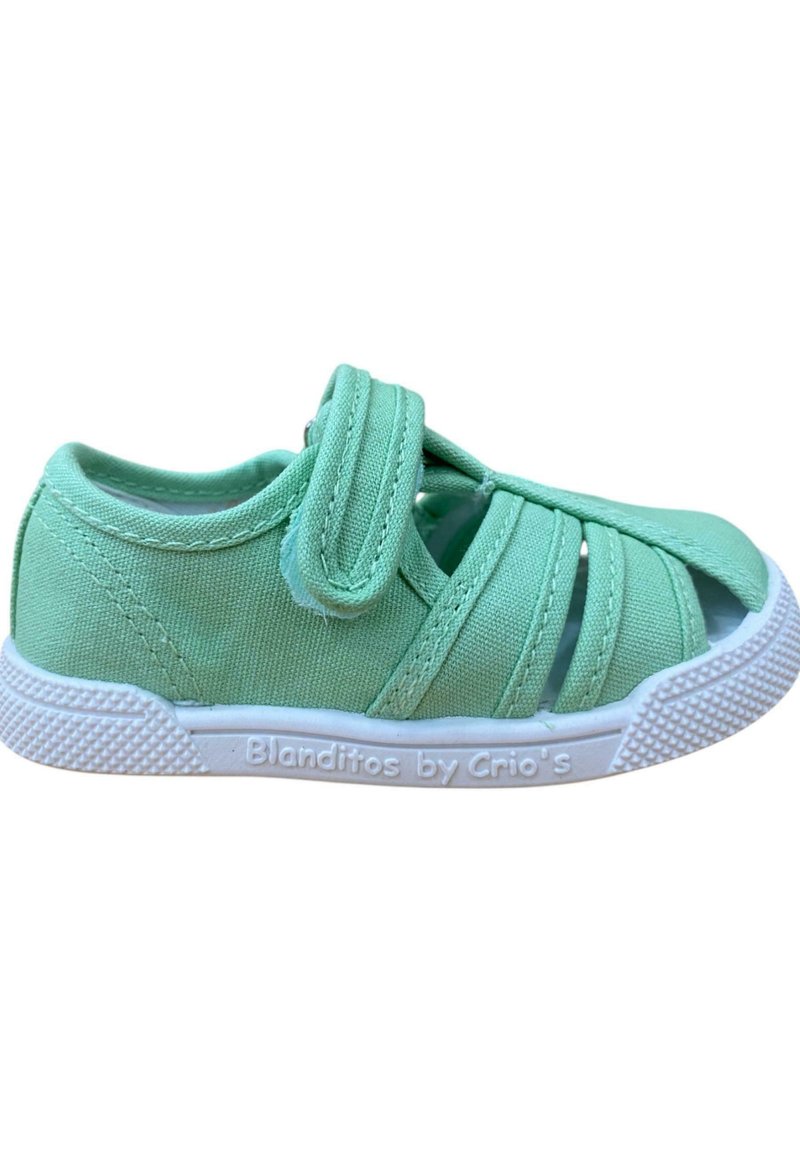 Zapatilla de lona verde con múltiples recortes, tira de velcro y suela de goma blanca. Superficie texturizada y diseño ligero para mayor comodidad.