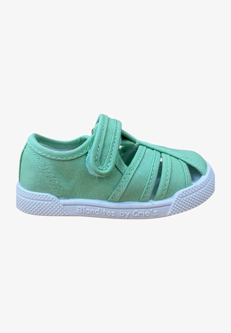 Zapatilla de lona verde con múltiples recortes, tira de velcro y suela de goma blanca. Superficie texturizada y diseño ligero para mayor comodidad.