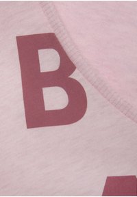 Roze stof met een gladde textuur heeft een grote, gedurfde, kastanjebruine letter "B" erop gedrukt. Het ontwerp heeft een ronde halslijn.
