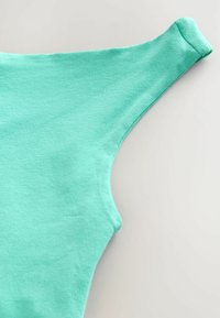 Top de algodón verde menta de manga corta con una textura suave y un escote amplio, que presenta un diseño ajustado y un área de hombros sin costuras.