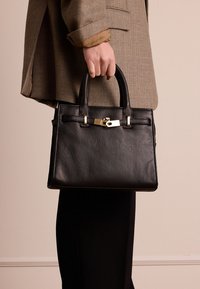 Borsa a mano in pelle nera con forma strutturata, manici superiori e accenti in hardware dorato. Presenta una superficie testurizzata e dettagli di cucitura a contrasto.