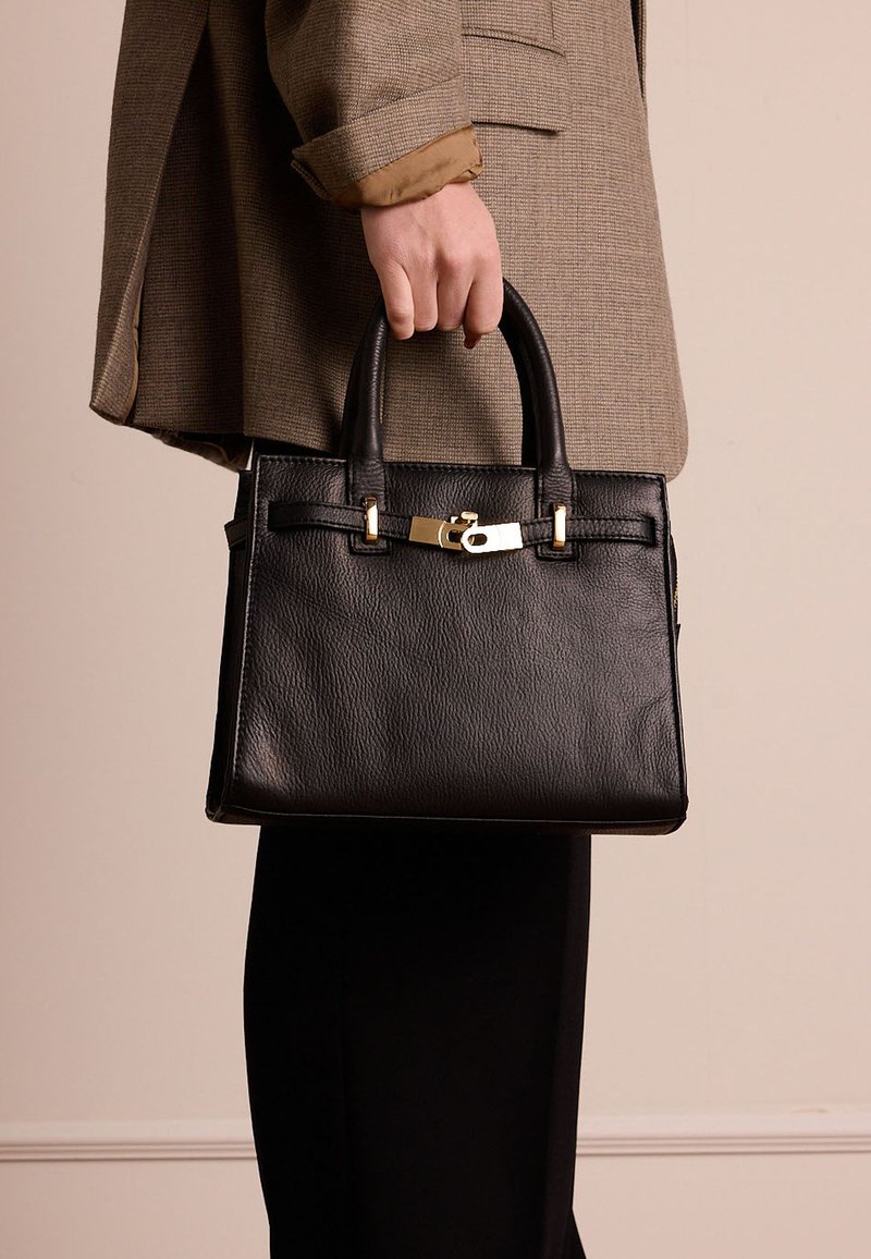 Borsa a mano in pelle nera con forma strutturata, manici superiori e accenti in hardware dorato. Presenta una superficie testurizzata e dettagli di cucitura a contrasto.