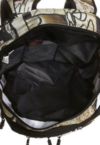 Interior de mochila con forro negro, bolsillo de malla texturizada y exterior con estampado gráfico. Cuenta con cremalleras resistentes y un compartimento espacioso.