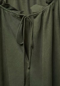 Țesătură verde măslinie cu o textură moale, având o sfoară de strângere cu capete legate și o fâșie de țesătură adunată pe gât.