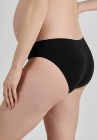 Juoda nėščiųjų apatinė apranga, aukštu liemeniu, glotnus audinys, visiškai apima klubus, be siūlių konstrukcija, minkštas elastingas juosmuo.