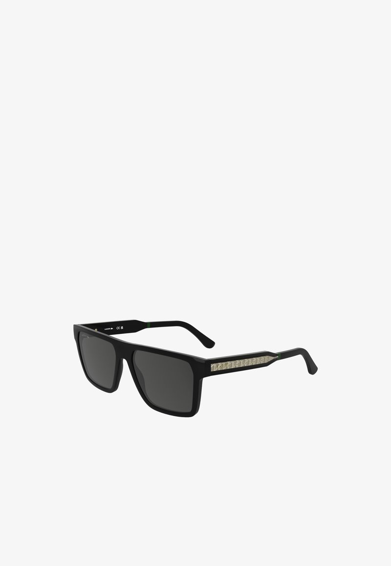 Črne sončne očala s kvadratnimi lečami. Tekstureirane črne ročke imajo dekorativno svetlo oblogo. Matt zaključek z zelenimi akcenti.