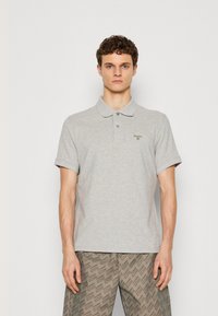 Γκρι πόλο μπλούζα από βαμβάκι, με γιακά, δυο κουμπιά στο κλείσιμο και μια διακριτική πράσινη λογότυπο στην αριστερή πλευρά του στήθους.