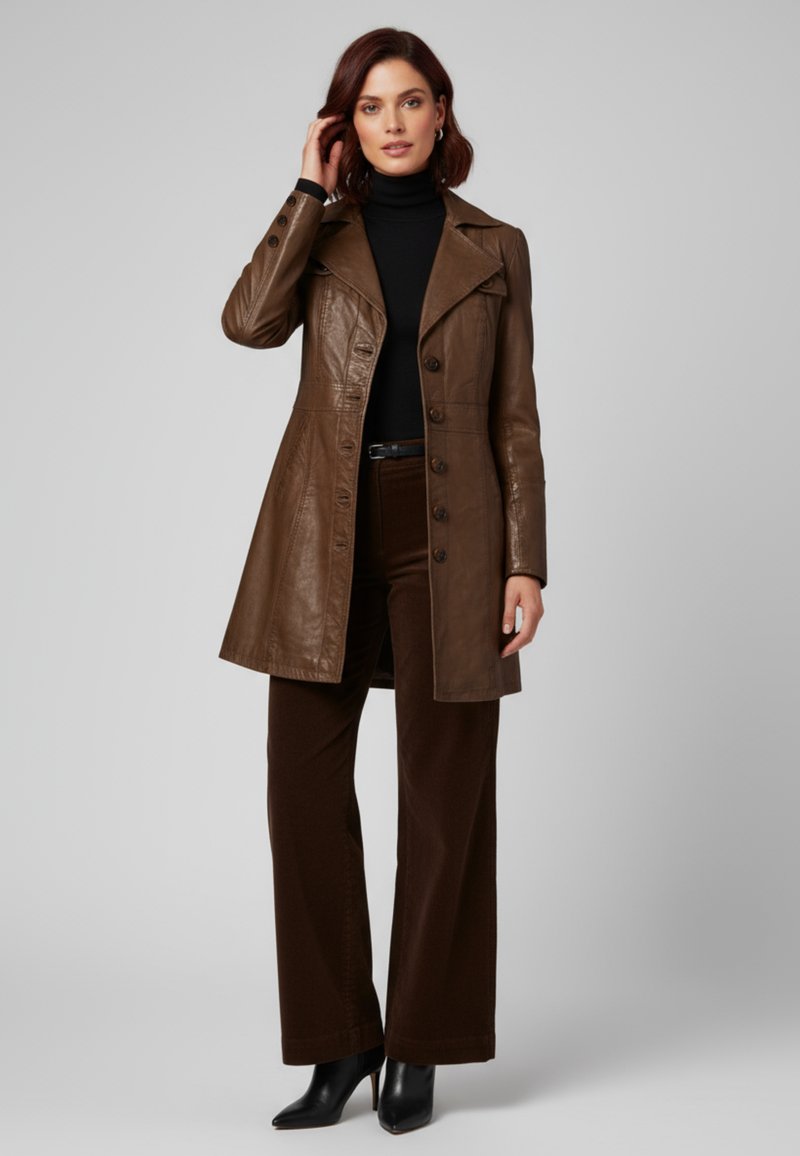 Bruine leren trenchcoat met een getailleerde taille, grote revers en knoopsluitingen. Gecombineerd met een zwarte coltrui, bruine broek en zwarte hakken.