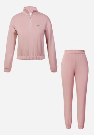 Two-piece athletic set in soft pink. The pullover has a zip neck, long sleeves, and a gathered hem; the pants feature an elastic waistband and cuffs.