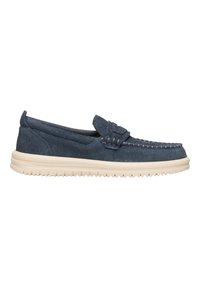 Zapato de ante tipo slip-on en azul oscuro con suela de goma blanca, costura decorativa y una pequeña tira en el empeine. Diseño plano y puntera redonda.