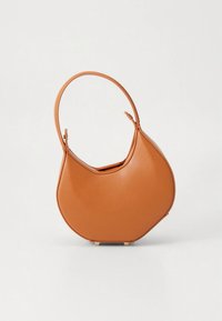 Braune Ledertasche mit einzigartigem, asymmetrischem Design, abgerundeter Form, einem einzelnen Griff und kleinen Füßen für Stabilität.
