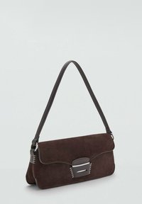 Sac en daim marron à bandoulière avec un rabat courbé, une quincaillerie en argent élégant et une courte bandoulière. Présente des accents de couture sur les côtés.