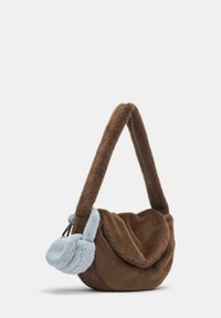 Barna műszőrme kézitáska egyedi formával, puha kék plüss részlettel. A pánt vastag és texturált, kiemelve a dizájnt.