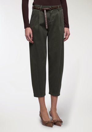 Pantaloni khaki a costine con vita alta, dotati di una cintura marrone con borchie. I pantaloni hanno tasche laterali e una texture liscia e morbida.