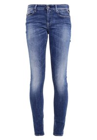 Jeans ajustados en denim azul medio, con detalles de desgaste y arrugas, una cremallera y cinco bolsillos. Tejido texturizado con un ligero estiramiento.