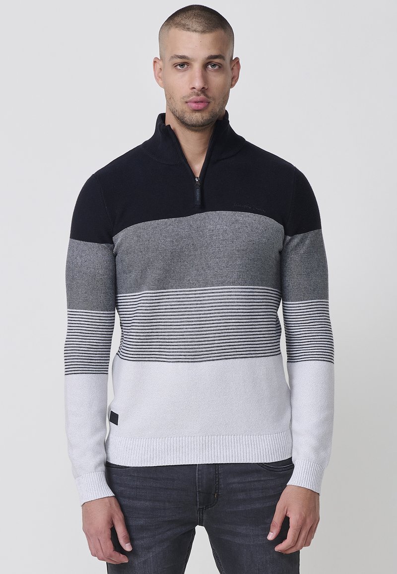 Gestrickter Pullover in Marineblau, Grau und Weiß mit einem halben Reißverschluss-Kragen, der horizontale Streifen und einen gerippten Saum aufweist. Sichtbares Logoschild an der Seite.
