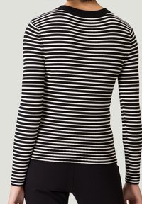 Długi rękaw swetra w czarno-białe paski, prążkowany, z okrągłym dekoltem i dopasowanym krojem, prezentujący gładką fakturę i wyraźny wzór.