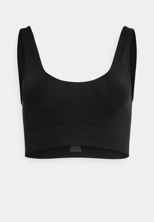 Crop top noir sans couture fabriqué en tissu doux et extensible. Il présente un décolleté large et des larges bretelles sans fermetures ni accessoires.