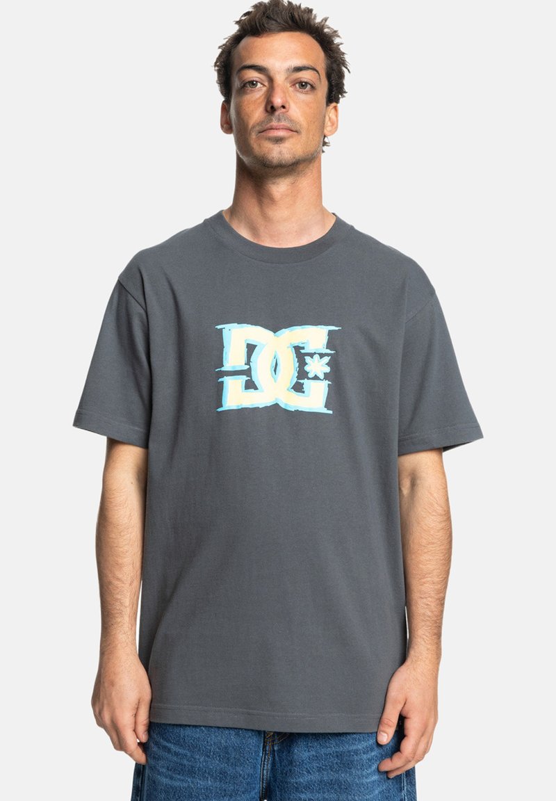 Grå bomulls t-shirt med en stor flerfärgad DC-logga på framsidan, korta ärmar och en avslappnad passform.