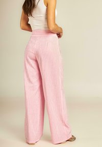 Roze wijde broek met verticale zilveren strepen, vervaardigd uit een zachte stof. De tailleband is aansluitend en heeft een subtiele glans.