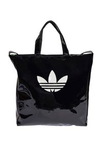 Black patent tote bag with two handles, featuring a large, white Adidas logo and three horizontal stripes on the front.