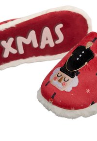 Zapatillas de felpa rojas con forro de piel sintética blanca, con un diseño navideño de un cascanueces y el texto "XMAS" en rosa. Forma redondeada.