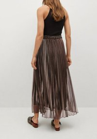 Plooirok van middellange lengte van doorschijnende, glanzende stof in bruin tinten, met een elastische tailleband en een gladde textuur.