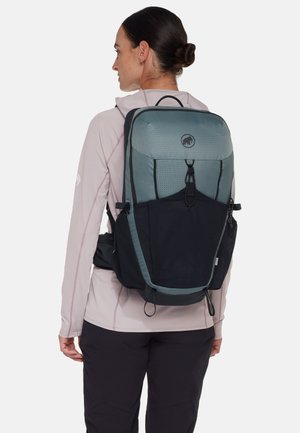 Rucksack mit grauem oberen Teil und schwarzem unteren Teil, mit strukturierter Oberfläche, verstellbaren Trägern und einer Seitentasche aus Mesh. Logo oben sichtbar.