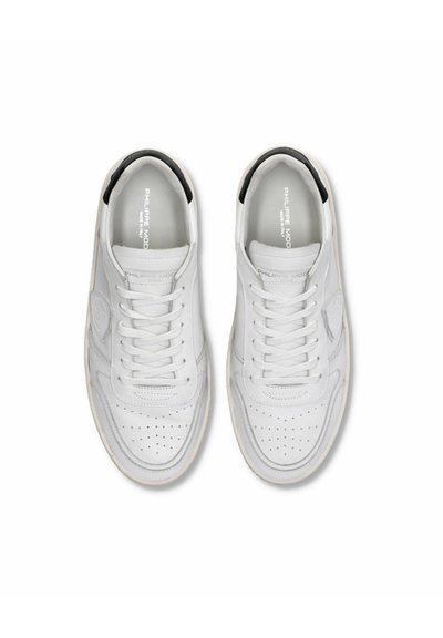 Baskets en cuir blanc avec une boîte à orteils perforée, lacets plats et un accent noir sur le col. Elles présentent une semelle texturée et un détail de logo.