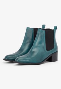 Botines de cuero color verde azulado con punteras redondeadas, paneles laterales elásticos negros y un tacón bajo cuadrado. Textura suave con detalles cosidos.