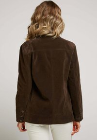 Veste en daim marron au coupé ajusté, dotée de poignets boutonnés, d'un col structuré et d'une texture lisse. Vue arrière, sans motifs visibles.