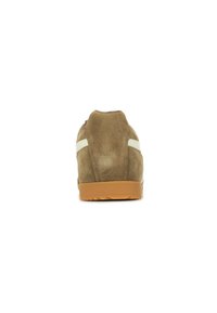Scarpa atletica in suede marrone con tacco arrotondato, dettaglio a striscia bianca e suola in gomma. La vista posteriore mostra una texture morbida e un design minimal.