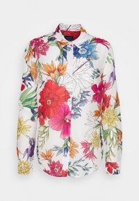 Camisa de flores de mangas largas con fondo blanco y vibrantes flores multicolores, con botones al frente y cuello extendido. Hecha de una tela ligera.