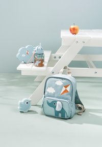 Mochila infantil azul claro con diseño de elefante, detalles de nubes y cometas, tela texturizada, con bolsillo delantero y correas ajustables.