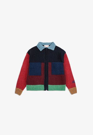 Strickjacke mit blauem Rippkragen, Reißverschluss und großen Ripp-Taschen. Sie hat mehrfarbige Einsätze in Marineblau, Rot, Kastanienbraun, Grün und Orange.