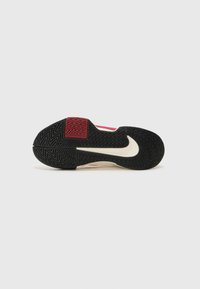 Athletic shoe sole with black rubber, herringbone pattern, and red accent. Ivory support midsole visible along the sides.